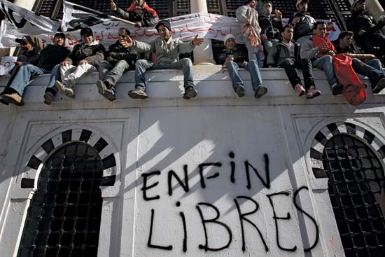 Demonstrators in the capital city of Tunis during the Jasmine revolution sitting on a wall (Photo credit: Christophe Ena/AP) Demonstrators in the capital city of Tunis during the Jasmine revolution sitting on a wall (Photo credit: Christophe Ena/AP)