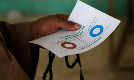 An Egyptian man holds a ballot before casting his vote at a polling station duri