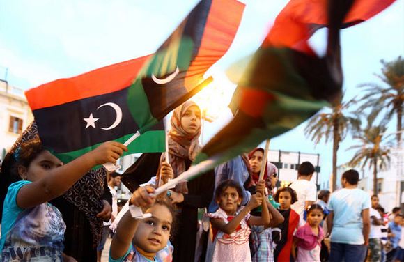 Libyans wave the national flag in Tripoli during celebrations for the third anniversary of the revolution's end on October 23, 2014. AFP/Mahmud Turkia AFP/Mahmud Turkia