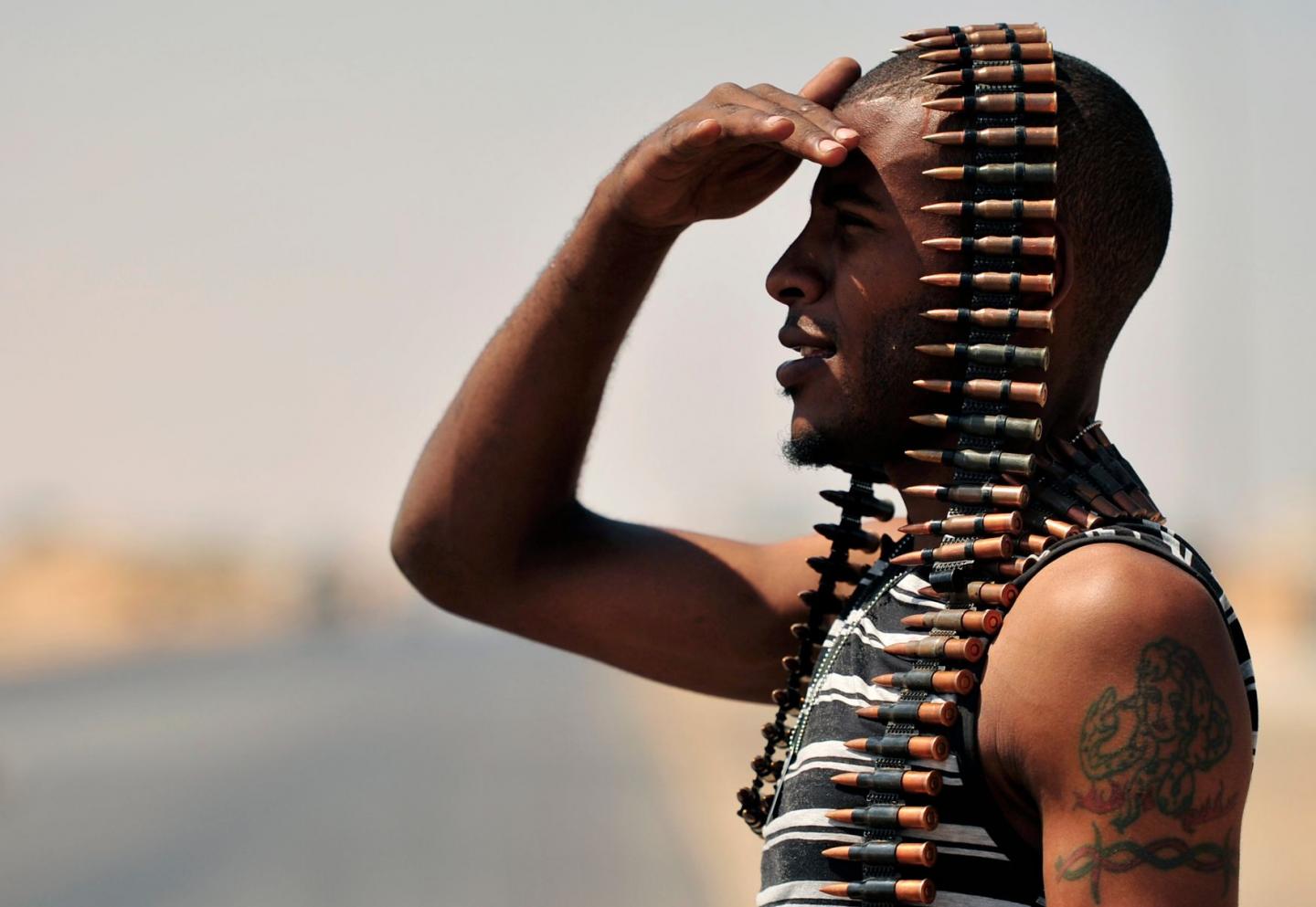 A Libyan rebel stands guard near the entrance of Ras Lanuf August 27, 2011 (photo credit: The National Interest)