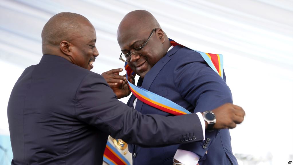 Congolese President Felix Tshisekedi, right, receives the presidential sash from outgoing president Joseph Kabila (photo credit: AP)