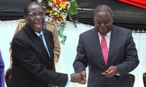 Robert Mugabe shakes hands with Morgan Tsvangirai after signing the new constitution into law (photo credit: Tsvangirayi Mukwazhi/AP) Robert Mugabe shakes hands with Morgan Tsvangirai after signing the new constitution into law (photo credit: Tsvangirayi Mukwazhi/AP)