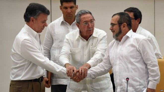 President Santos (left) and Timochenko shook hands after a meeting facilitated by Raul Castro (centre) [photo credit: AFP]