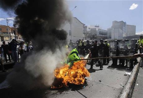 A protester sets fire to a banner with an image depicting President Correa outside the National Assembly where lawmakers debate a series of constitutional reforms on 3 Dec. 2015. (photo credit: Dolores Ochoa) A protester sets fire to a banner with an image depicting President Correa outside the National Assembly where lawmakers debate a series of constitutional reforms on 3 Dec. 2015. (photo credit: Dolores Ochoa)
