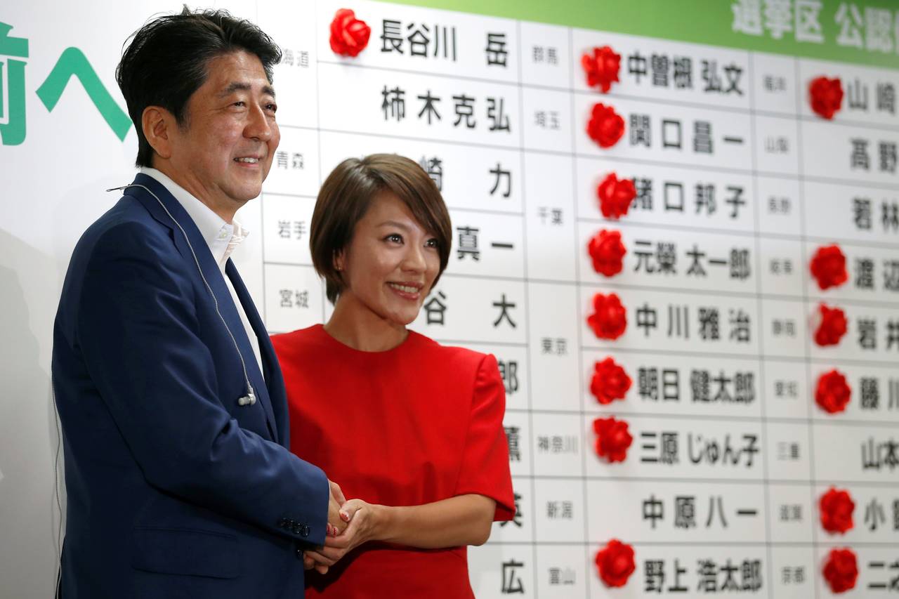 Japanese Prime Minister Shinzo Abe shakes hands with Eriko Imai, a candidate for his Liberal Democratic Party (photo credit: Toru Hanai/REUTERS)