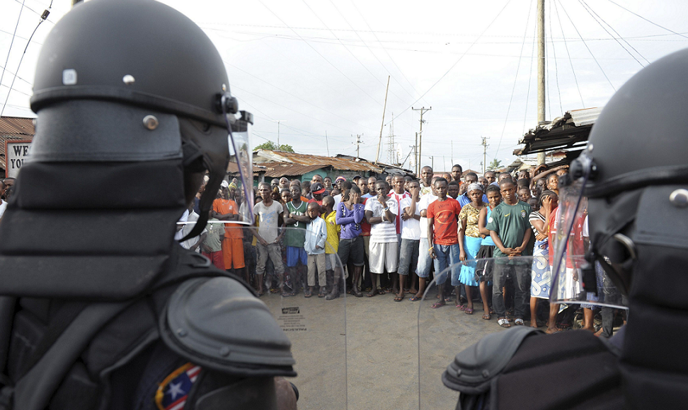 Liberian security forces stand in front of protesters after clashes at West Point neighbourhood in Monrovia, 20 August 2014. Police in the Liberian capital Monrovia fired live rounds and teargas on Wednesday to disperse a stone-throwing crowd trying to break an Ebola quarantine imposed on their neighbourhood. Reuters Liberia police in Monrovia. Reuters