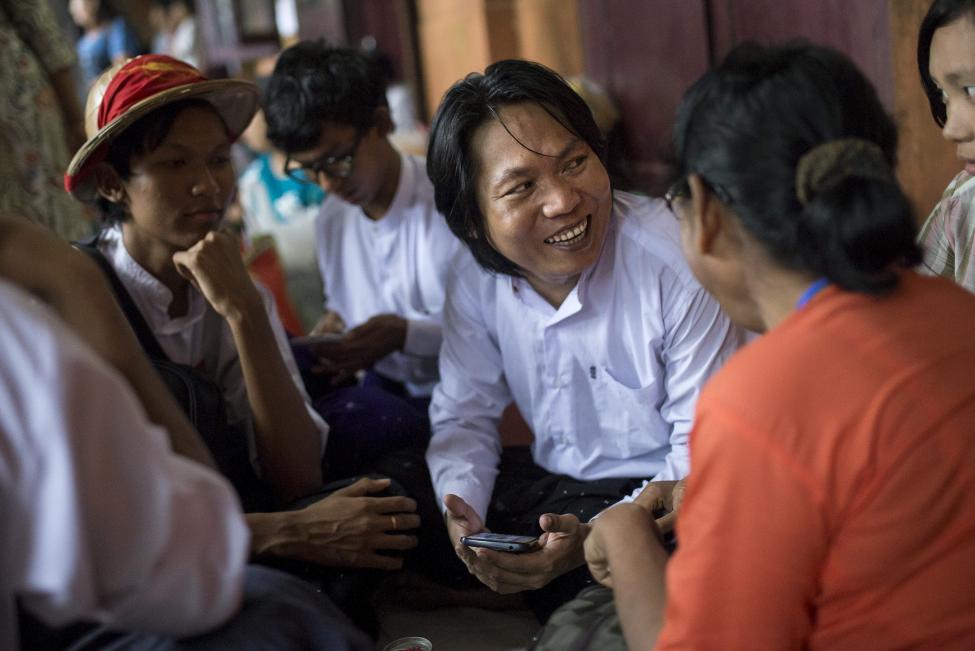 Student activist Nanda Sit Aung talks to his family and friends during a lunch break at a mass trial of the student protesters at Tharrawaddy court, Tharrawaddy, Bago, August 25, 2015 [photo credit: Reuters]