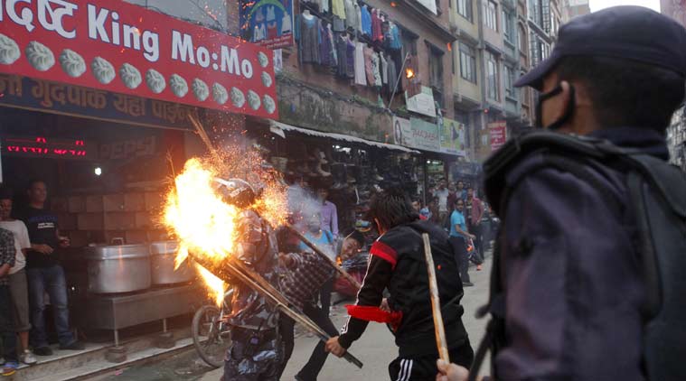 Nepalese protesters hit a policeman with a torch during a rally in Kathmandu, Nepal, Saturday, August 15, 2015 [photo credit: AP]