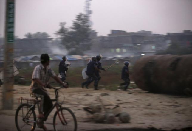 Nepalese police personnel chase Madhesi protesters (Photo credit: Reuters/Navesh Chitrakar)