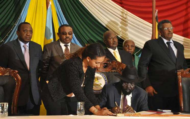 South Sudan’s President Salva Kiir (seated) signs a peace agreement in Juba, August 26, 2015. (Photo credit: Reuters/Jok Solomu)