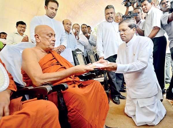 Maithripala Sirisena presents the first copy of his manifesto to Leader of the Movement for Social Justice Ven. Maduluwawe Sobitha Thero (photo credit: Shehan Gunasekera, Daily FT)