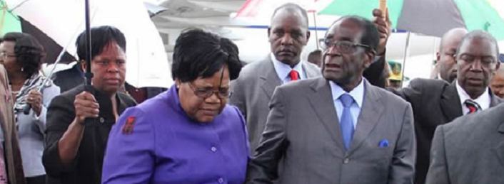Zimbabwean President Robert Mugabe (R) is greeted by Vice President Joice Mujuru (L) as he returns home to Harare, April 12, 2012, after a trip to Singapore that had ignited speculation the veteran leader was seriously ill Zimbabwean President Robert Mugabe
