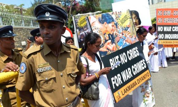 Police stand guard as activists take part in a recent demonstration against a proposed US-led UN resolution to investigate Sri Lanka for alleged war crimes outside the US embassy in Colombo. (photo credit: AFP)
