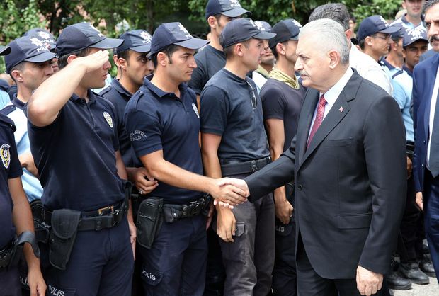 Turkish Prime Minister Binali Yildirim (L) shaking hands with Turkish police officers  (photo credit: Prime Minister's press office)