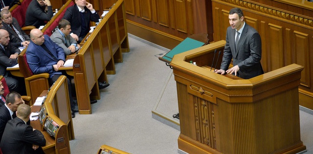 Vitali Klitschko, head of the opposition UDAR party (Ukrainian Democratic Alliance for Reform), right, addresses members of parliament during a parliamentary session in Kiev on Feb. 4, 2014. Photographer: Sergei Supinsky/AFP/Getty Images