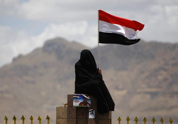 A woman holds the Yemenite national flag (photo credit:REUTERS)