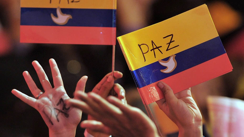 Supporters of the peace (Paz) process hold the Colombian flag (photo credit: Warscapes)